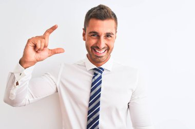 Young handsome elegant business man over isolated background smiling and confident gesturing with hand doing small size sign with fingers looking and the camera. Measure concept.