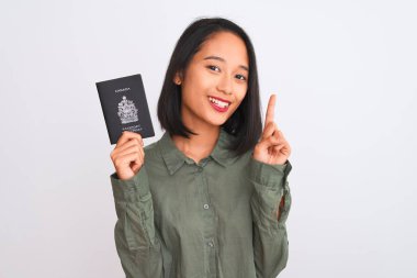 Kanada pasaportu taşıyan güzel Çinli kadın izole edilmiş beyaz arka plan üzerinde bir fikir veya soru işareti ile şaşırdı.