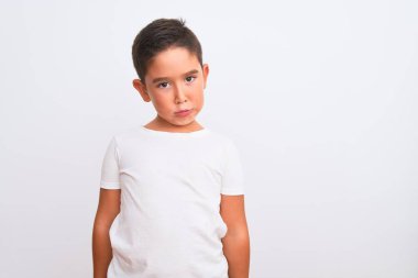 Beautiful kid boy wearing casual t-shirt standing over isolated white background depressed and worry for distress, crying angry and afraid. Sad expression.