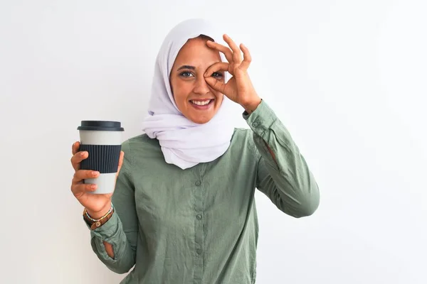 若いです美しいですアラブ女性身に着けています伝統的なイスラム教徒のヒジャーブコーヒーを飲みます幸せな顔笑顔とともにOkサインをします手で指を通して見て — ストック写真
