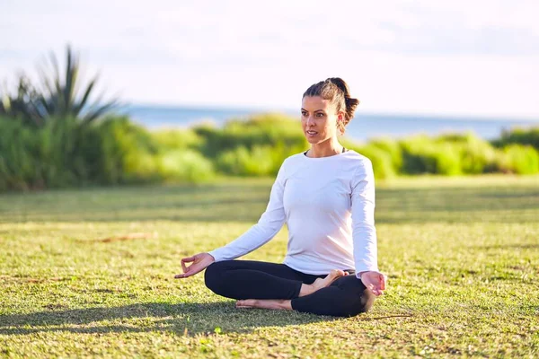 Junge Schöne Sportlerin Praktiziert Yoga Trainer Sitzt Auf Dem Rasen — Stockfoto