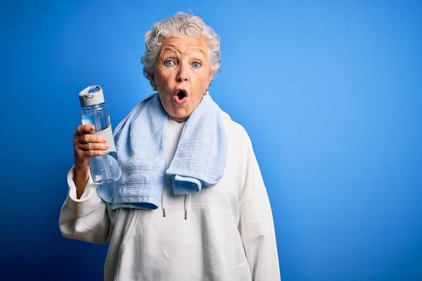 Senior Beautiful Sporty Woman Holding Bottle Water Standing Isolated Blue — Stockfoto