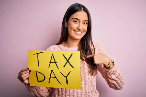 Junge Schöne Brünette Frau Hält Papier Mit Steuertagsmeldung Über Rosa — Stockfoto