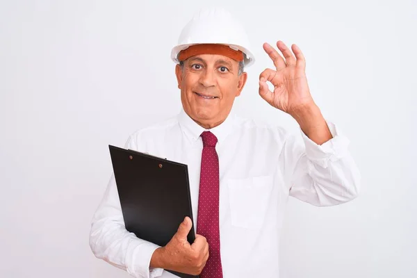 Starszy Architekt Noszący Hełm Bezpieczeństwa Trzymając Schowek Izolowanym Białym Tle — Zdjęcie stockowe