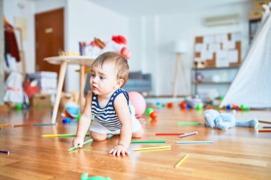Anaokulunda bir sürü oyuncakla oynayan sevimli bir çocuk.