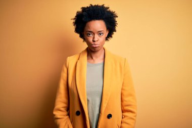 Young beautiful African American afro businesswoman with curly hair wearing yellow jacket depressed and worry for distress, crying angry and afraid. Sad expression.