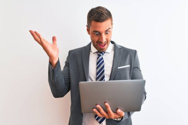 Young handsome business man working using computer laptop over isolated background very happy and excited, winner expression celebrating victory screaming with big smile and raised hands