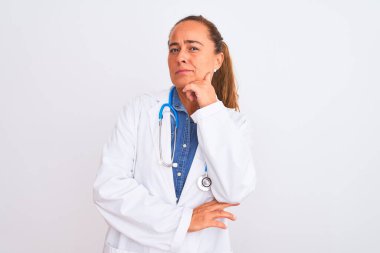 Soyutlanmış arka planda steteskop takan orta yaşlı olgun bir kadın kameraya kollarını kavuşturarak ve çenesini kaldırarak gülümsüyor. Olumlu düşünüyorum..