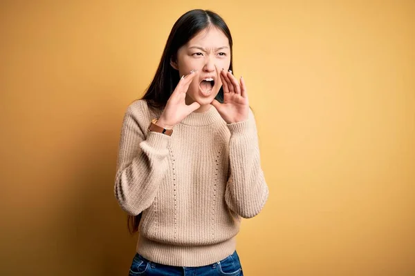 위에서 캐주얼 스웨터를 아름다운 아시아 손으로 막으며 목소리로 소리로 외치고 — 스톡 사진