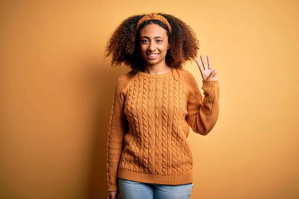 若いですアフリカ系アメリカ人女性とともにアフロ髪身に着けていますカジュアルセーター上の黄色の背景表示と指摘指番号3ながら笑顔自信と幸せ — ストック写真