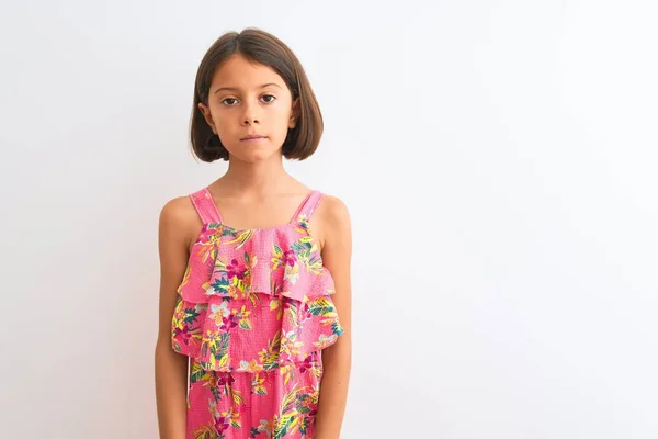 年轻漂亮的小女孩穿着粉红色的花衣服站在孤立的白色背景上 脸上带着严肃的表情 简单而自然地看着相机 — 图库照片