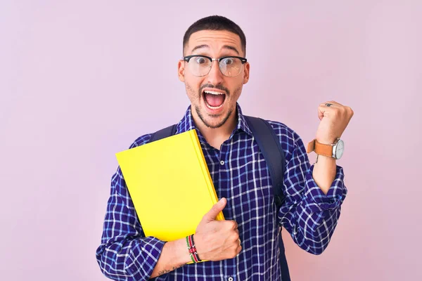 Young Handsome Student Man Holding Book Isolated Background Screaming Proud — Stok fotoğraf