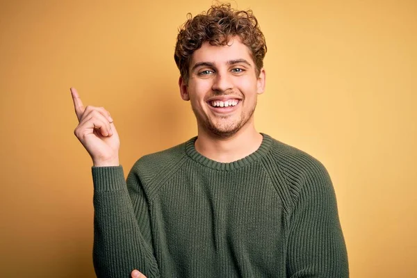 Young Blond Handsome Man Curly Hair Wearing Green Sweater Yellow — Stock Photo, Image