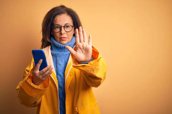 Middelbare Leeftijd Vrouw Dragen Gele Regenjas Met Behulp Van Smartphone — Stockfoto