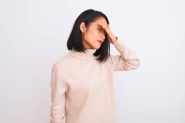 Balıkçı yaka kazak giyen genç Çinli bir kadın izole edilmiş beyaz arka planda duruyor gözlerini eliyle kapatıyor, ciddi ve üzgün görünüyor. Görme, saklama ve reddetme konsepti