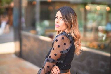 Mutlu ve kendinden emin gülümseyen genç ve güzel bir kadın. Şehir caddesinde ayakta ve yürüyorum.