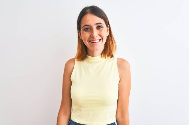 Güzel kızıl saçlı kadın izole edilmiş arka planda sarı bir tişört giyiyor ve yüzünde mutlu ve havalı bir gülümseme var. Şanslı kişi..