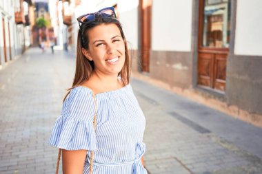 Romantik köyde genç ve güzel bir kadın güneşli bir günde kasaba sokaklarında yürüyor.