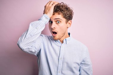 Sarışın, kıvırcık saçlı, beyaz arka planda çizgili tişört giyen, kafası bir karış havada genç bir adam. Hatayı hatırla. Unuttum, kötü hafıza konsepti.