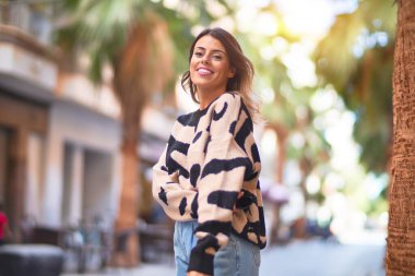 Mutlu ve kendinden emin gülümseyen genç ve güzel bir kadın. Şehir caddesinde ayakta ve yürüyorum.