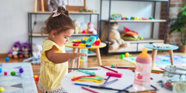 Anaokulunun masasında oyuncaklarla oynayan güzel çocuk.