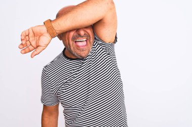 Orta yaşlı yakışıklı adam izole edilmiş beyaz arka plan üzerine çizgili donanma tişörtü giyiyor. Gözleri kollarıyla gülüyor, neşeli ve komik. Kör kavram.
