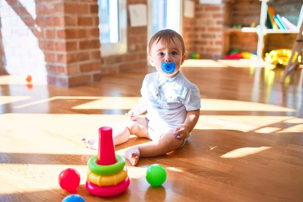 Bedårande Barn Sitter Golvet Med Napphållare Runt Massor Leksaker Dagis — Stockfoto