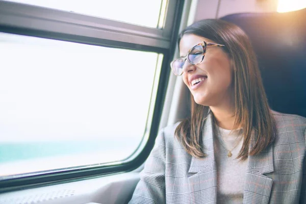 年轻美丽的女人开心而自信地微笑着 坐在那里 面带微笑坐火车旅行 — 图库照片