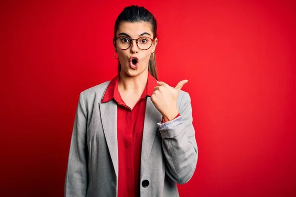 Young Beautiful Brunette Businesswoman Wearing Jacket Glasses Red Background Surprised — 스톡 사진