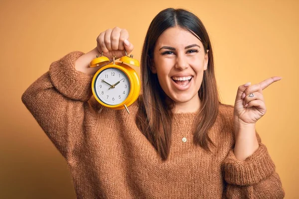 Jeune Belle Femme Tenant Réveil Debout Sur Fond Orange Isolé — Photo