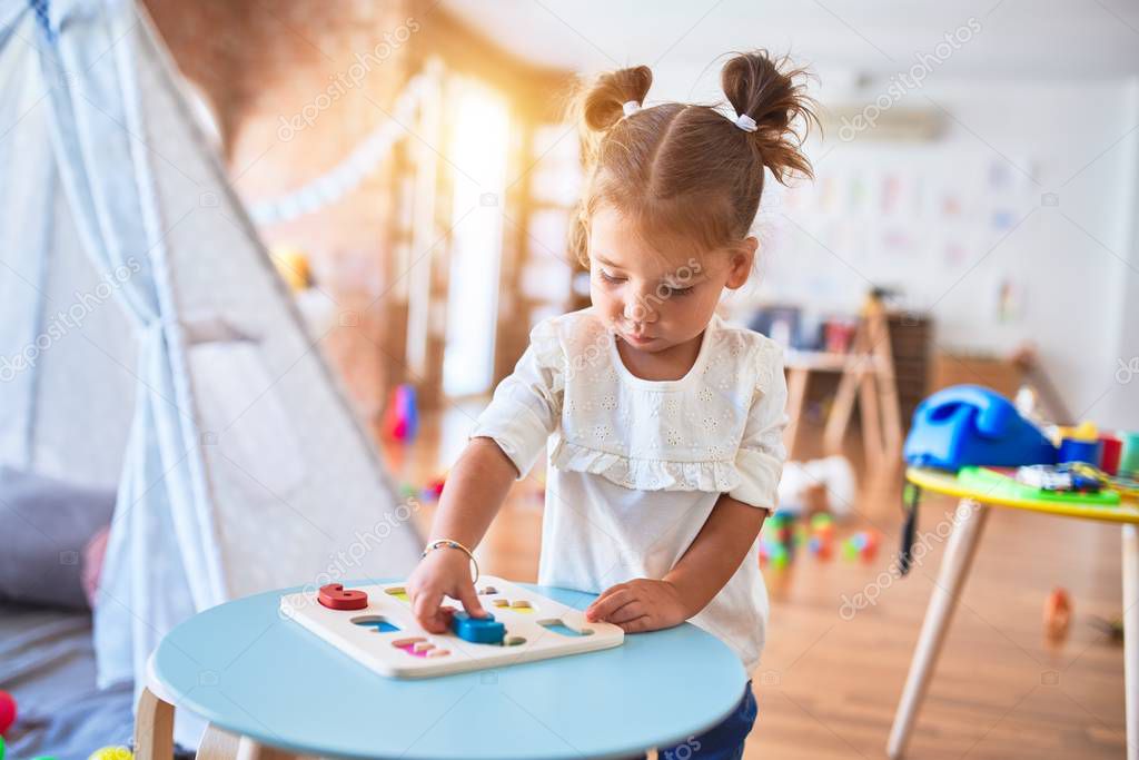 Young beautiful toddler learning mathematics playing with maths game at kindergaten