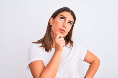 Güzel ve genç esmer bir kadının portresi izole edilmiş beyaz arka planda duruyor, elleri çenesinde soru sorarken, düşünceli bir ifade takınıyor. Düşünceli bir yüzle gülümsüyor. Şüphe kavramı.