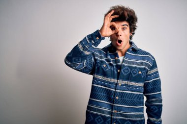 İzole edilmiş beyaz arka plan üzerinde duran sıradan tişörtlü genç yakışıklı adam şaşırmış yüz ve parmaklarından bakan gözlerle şok edici hareketler yapıyor. İnançsız ifade.