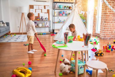 Anaokulunda bir sürü oyuncakla oynayan sevimli sarışın ikizler.