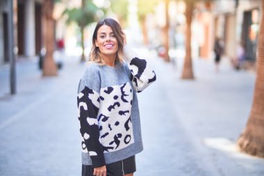 Mutlu ve kendinden emin gülümseyen genç ve güzel bir kadın. Şehir caddesinde ayakta ve yürüyorum.