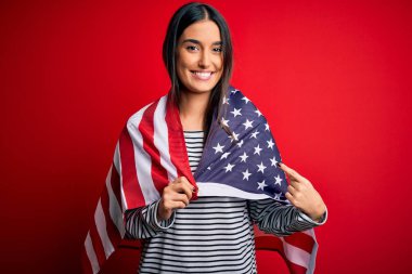 Amerika Birleşik Devletleri bayrağı taşıyan güzel, vatansever bir kadın bağımsızlık gününde elini ve parmağını göstererek mutlu mesut işaret ediyor.