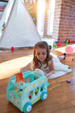 Anaokulunda oyuncak oyuncaklarıyla oynayan sevimli sarışın çocuk.