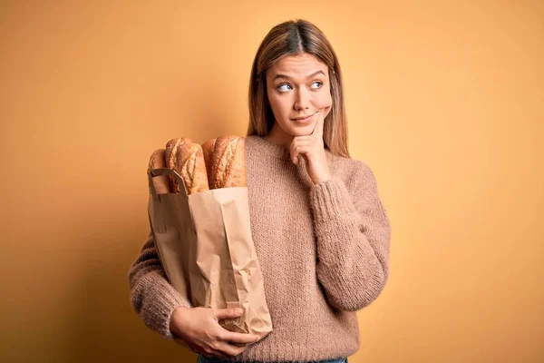 Young Beautiful Woman Holding Paper Bag Bread Isolated Yellow Background — 图库照片