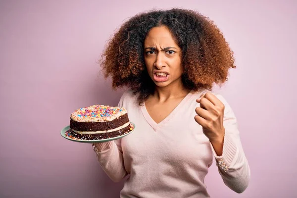 若いですアフリカ系アメリカ人女性とともにアフロヘア保持おいしい誕生日ケーキいらいらし 怒りで叫んで 狂気と大声で手を上げ 怒りの概念 — ストック写真