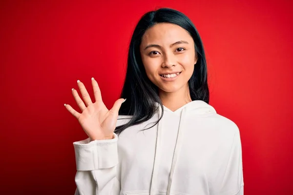 Jonge Mooie Chinese Sportieve Vrouw Dragen Sweatshirt Geïsoleerde Rode Achtergrond — Stockfoto