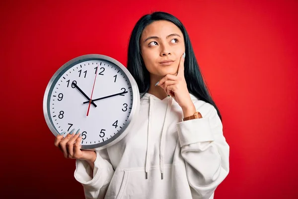 Young Beautiful Chinese Woman Holding Big Clock Standing Isolated Red — Stok fotoğraf