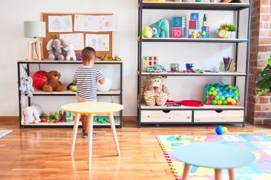 Anaokulunda renkli küçük toplarla oynayan güzel bir çocuk.