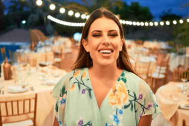 Parti şöleninde mutlu ve neşeli gülümseyen gelinlikli güzel ve zarif bir kadın.