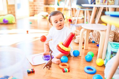 Anaokulunda renkli oyuncaklar arasında mutlu güzel bir bebek.