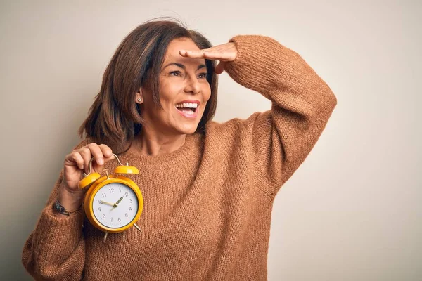 Brunetka Średnim Wieku Trzymająca Klasyczny Budzik Odosobnionym Tle Bardzo Szczęśliwa — Zdjęcie stockowe