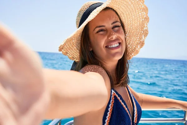 年轻美丽的女人在一个阳光灿烂的假日驾船 用智能手机开心地笑着自拍 — 图库照片