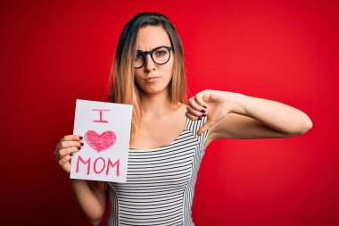 Elinde aşk dolu bir kağıt tutan genç bir kadın. Anneler gününü kızgın bir suratla kutluyor. Negatif işaretler baş parmakları aşağıda, reddedilme konsepti ise reddedilmiş.