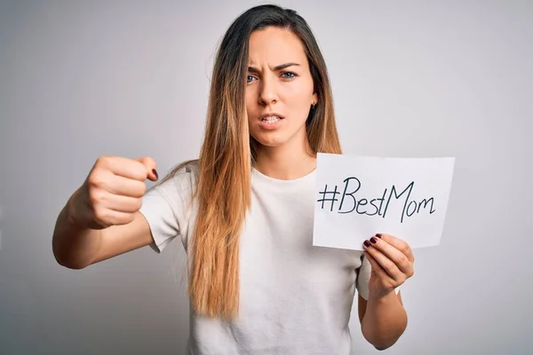 Young beautiful woman holding paper with best mom message celebrating mothers day annoyed and frustrated shouting with anger, crazy and yelling with raised hand, anger concept