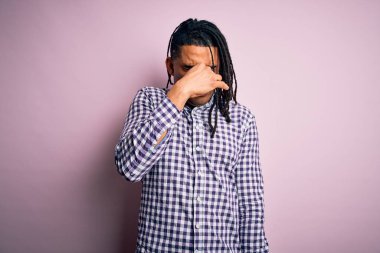 Rastgele gömlek giyen Afro-Amerikan genç yakışıklı adam pis ve iğrenç bir koku alıyor. Nefesini burnunda tutuyor. Kötü kokuyor.