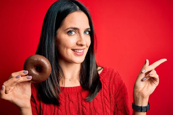 Young Brunette Woman Blue Eyes Eating Chocolate Doughnut Red Isolated — ストック写真